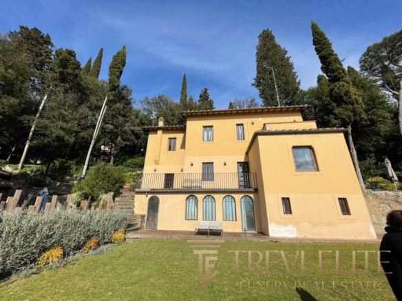 Роскошный дом в Италии возле зелёных деревьев и на фоне голубого неба, идеально подходящий для элитной недвижимости.