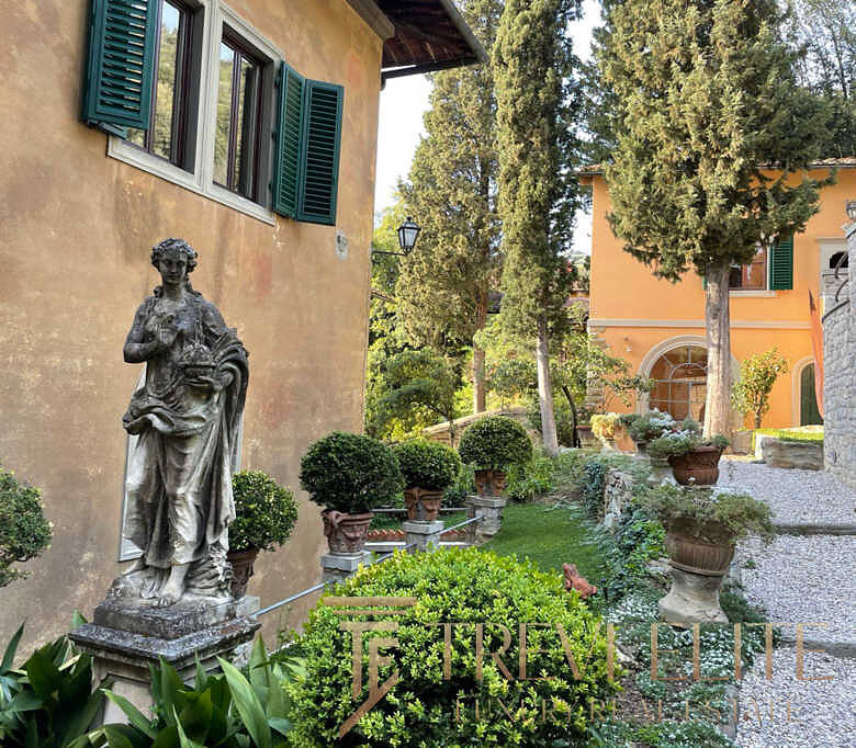 Уникальный зеленый двор с античной статуей и ухоженными кустами, создающими атмосферу итальянского дома премиум класса. Идеальное место для отдыха и наслаждения природой.