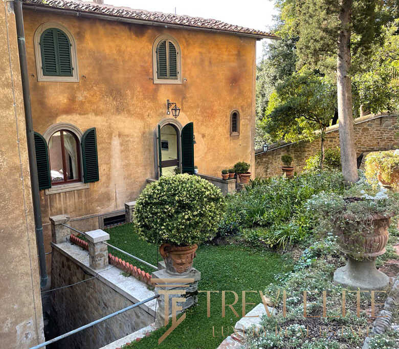 Уютный итальянский загородный дом с роскошным садом и классическим декором, расположенный в живописной местности для элитной аренды или покупки.