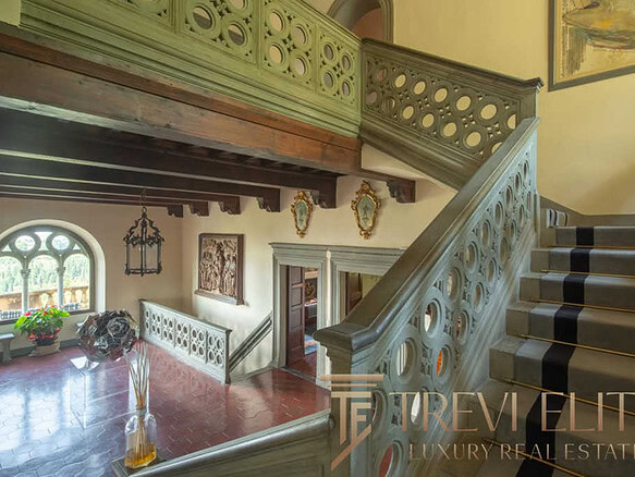 Элитный интерьеров со старинной лестницей в роскошных апартаментах с изысканной отделкой, историческим стилем и высокими потолками, создающими атмосферу утонченности и уюта.