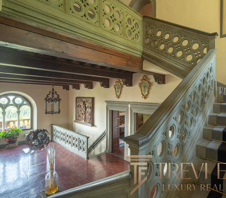 Элитный интерьеров со старинной лестницей в роскошных апартаментах с изысканной отделкой, историческим стилем и высокими потолками, создающими атмосферу утонченности и уюта.