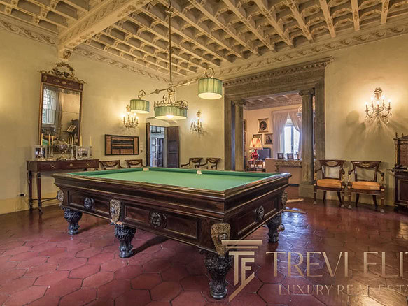 Роскошный интерьер с антикварным бильярдным столом в элегантной гостиной с классическим декором. Идеальное сочетание исторического стиля и современного комфорта для ценителей элитной недвижимости.