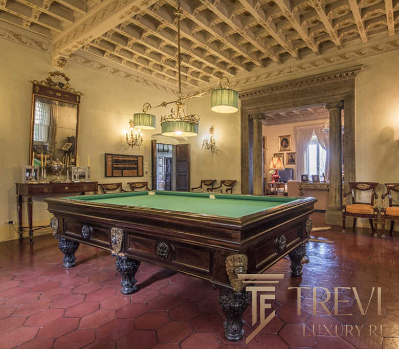 Роскошный интерьер с антикварным бильярдным столом в элегантной гостиной с классическим декором. Идеальное сочетание исторического стиля и современного комфорта для ценителей элитной недвижимости.
