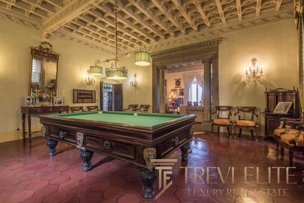 Роскошный интерьер с антикварным бильярдным столом в элегантной гостиной с классическим декором. Идеальное сочетание исторического стиля и современного комфорта для ценителей элитной недвижимости.