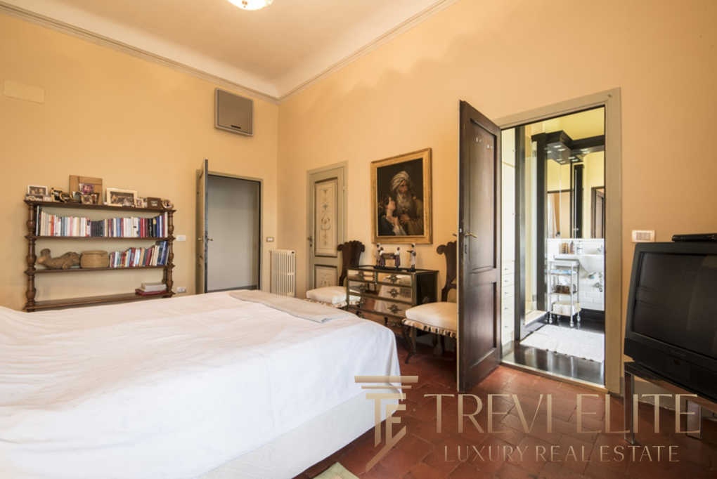 Уютная спальня с классической мебелью и выходом на балкон, создающая атмосферу уюта и роскоши в элитной недвижимости.