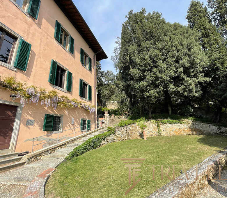 Роскошный дом с ухоженным садом и зелеными деревьями, расположенный в тихом районе, идеально подходит для элитной недвижимости и комфортного проживания.