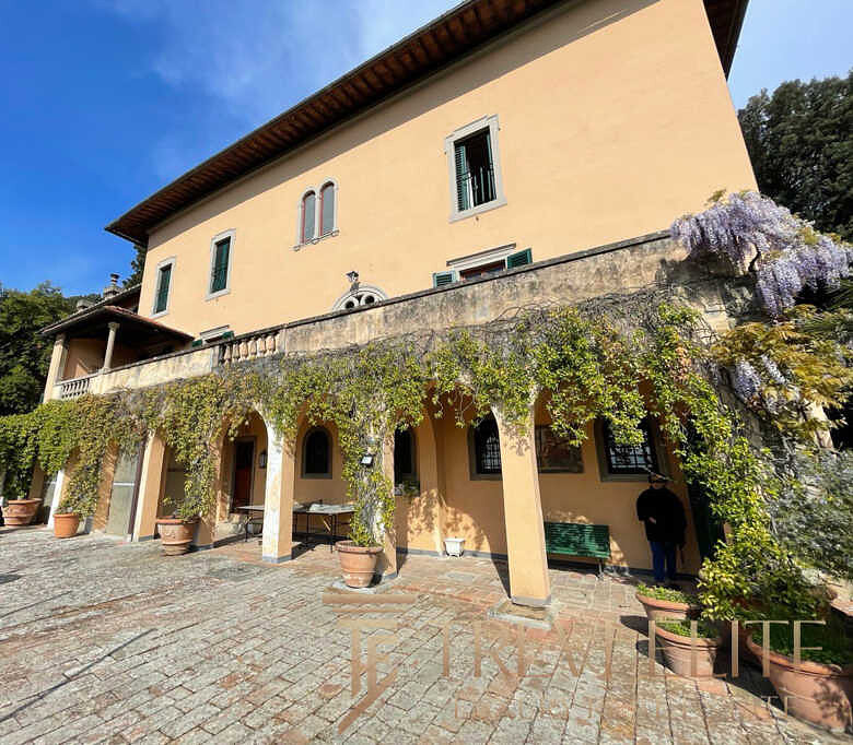 Уединенный итальянский особняк с виноградной лозой и уютной террасой, окруженной зеленью, в живописной сельской местности Италии.