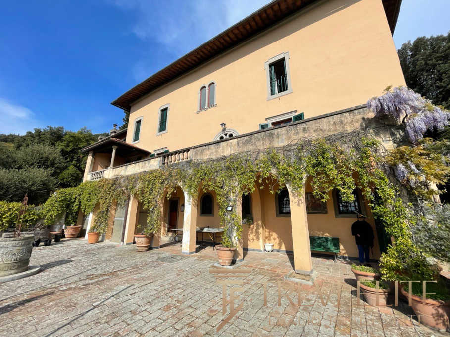 Уединенный итальянский особняк с виноградной лозой и уютной террасой, окруженной зеленью, в живописной сельской местности Италии.