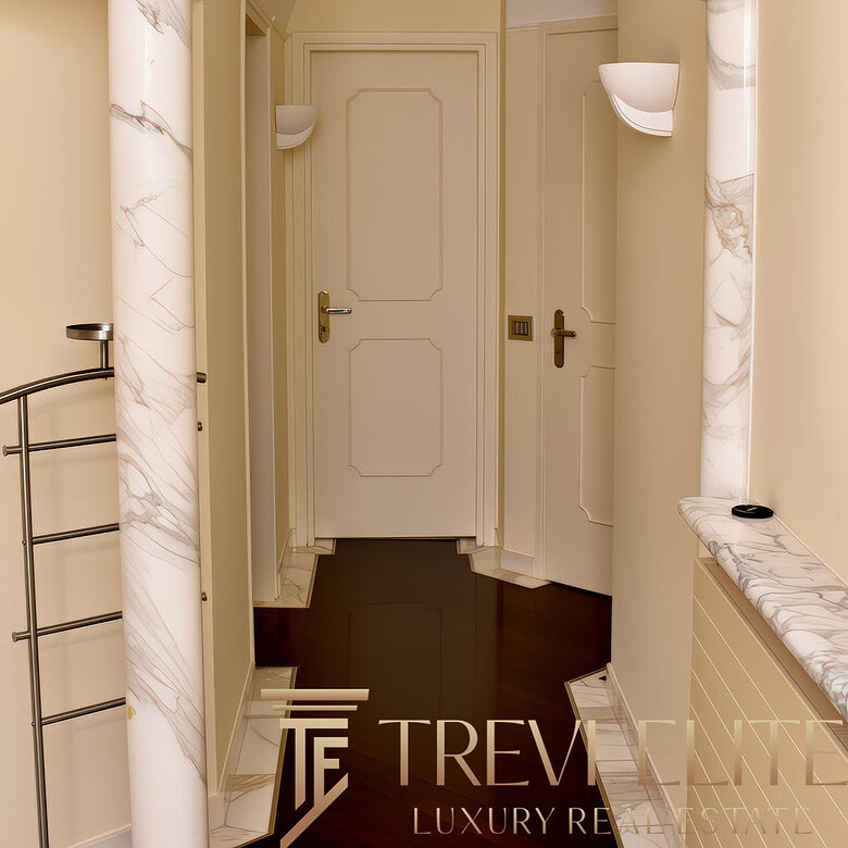 Элегантный коридор в классическом стиле с мраморными колоннами и светильниками, окрашенными в мягкие светлые оттенки, создает атмосферу роскоши и уюта.