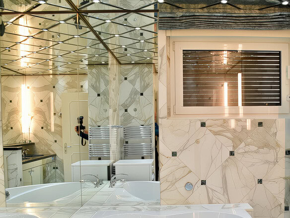 Элегантная современная ванная комната с мраморными стенами и большим окном, создающая атмосферу роскоши и комфорта. Специально для клиентов агентства недвижимости Треви Элит.