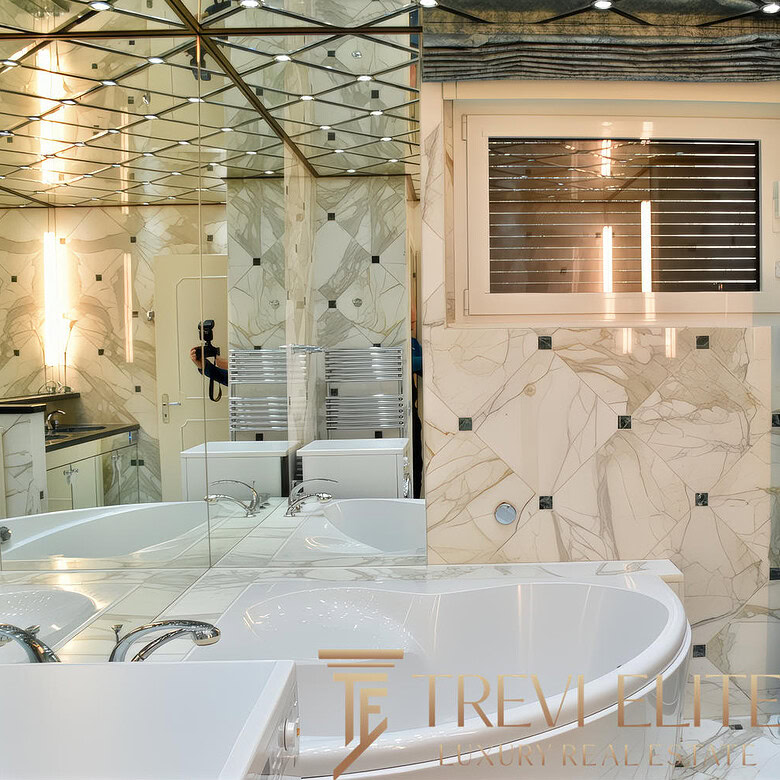 Элегантная современная ванная комната с мраморными стенами и большим окном, создающая атмосферу роскоши и комфорта. Специально для клиентов агентства недвижимости Треви Элит.