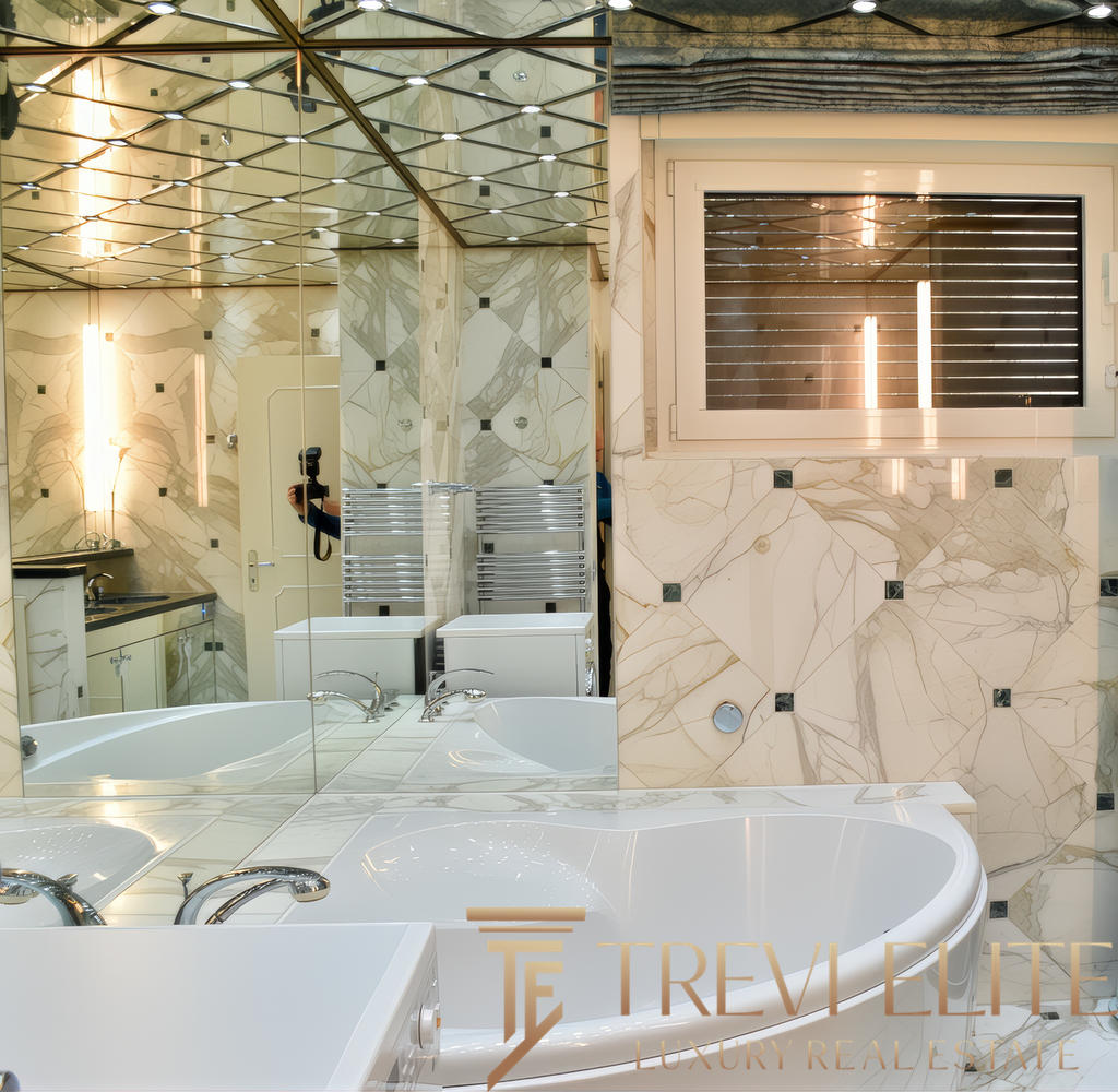 Элегантная современная ванная комната с мраморными стенами и большим окном, создающая атмосферу роскоши и комфорта. Специально для клиентов агентства недвижимости Треви Элит.