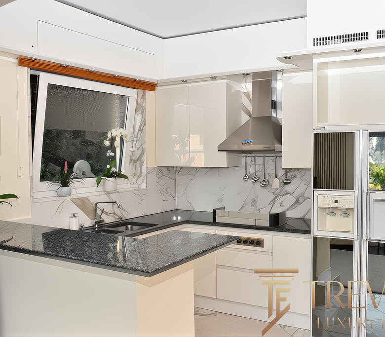 Современная кухня с белыми фасадами, мраморной столешницей и встроенной техникой, стильное и функциональное решение для комфорта и уюта.