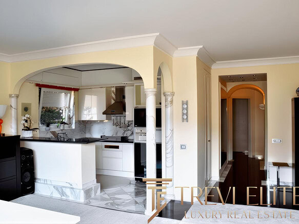 Современная кухня с насыщенными белыми и мраморными элементами, уютным освещением и просторным интерьером в стиле роскоши, идеально подходящая для комфортной жизни и встреч с друзьями.