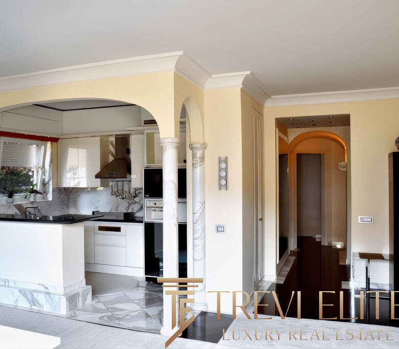 Современная кухня с насыщенными белыми и мраморными элементами, уютным освещением и просторным интерьером в стиле роскоши, идеально подходящая для комфортной жизни и встреч с друзьями.