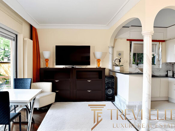 Современная гостиная с мягкой мебелью, телевизором и стильным интерьером в элитной недвижимости Трева Элит, идеально подходит для комфортного отдыха и семейных встреч.