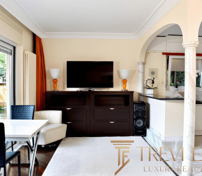 Современная гостиная с мягкой мебелью, телевизором и стильным интерьером в элитной недвижимости Трева Элит, идеально подходит для комфортного отдыха и семейных встреч.