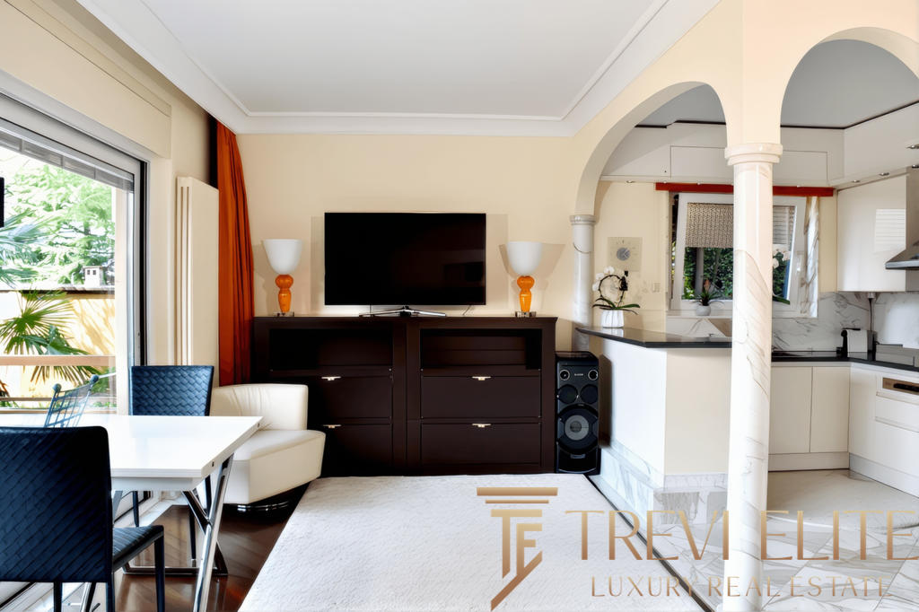 Современная гостиная с мягкой мебелью, телевизором и стильным интерьером в элитной недвижимости Трева Элит, идеально подходит для комфортного отдыха и семейных встреч.