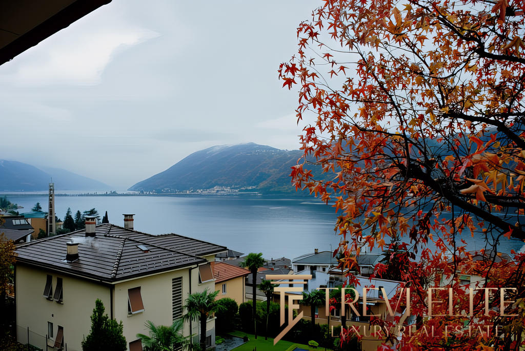 Очаровательный вид на озеро и горы с живописной осенней листвой, показывающий элитные дома у воды, ideal для презентации эксклюзивной недвижимости в Треви Элит.