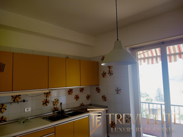 Современная кухня с яркими фасадами и стильной отделкой, светлым освещением и балконом, выходящим на живописный пейзаж, идеально подходит для уютного проживания.