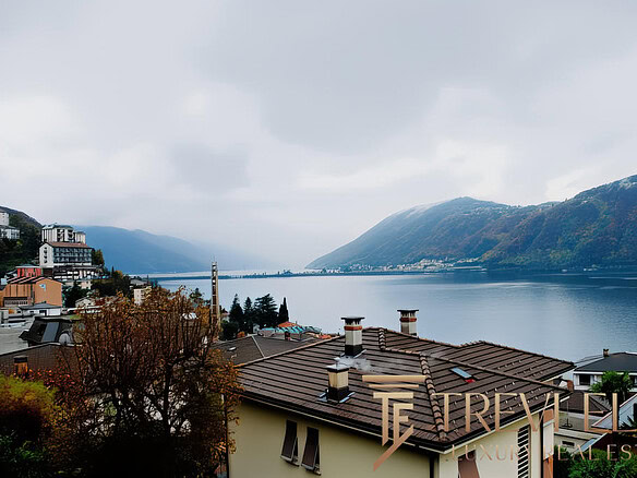 Красивый вид на озеро с жилищными домами и горами, уютная атмосфера, природа и спокойствие, идеально для покупки недвижимости у Треви Элит.