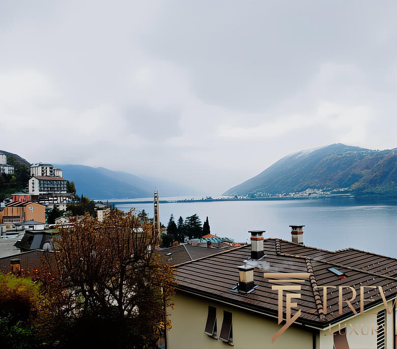 Красивый вид на озеро с жилищными домами и горами, уютная атмосфера, природа и спокойствие, идеально для покупки недвижимости у Треви Элит.