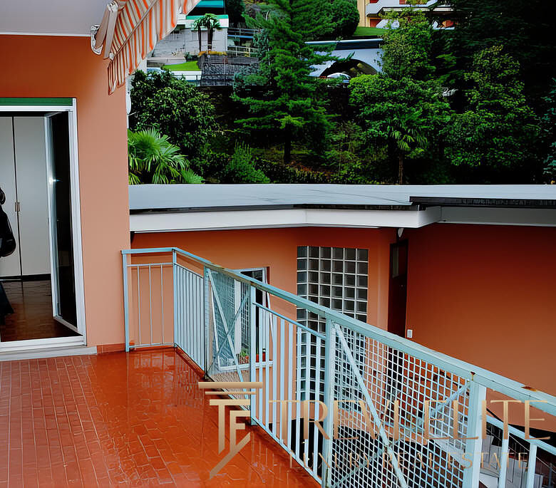 Окно балкона с видом на зелень и современные жилые комплексы, стильный интерьер, уютная уютная терраса, дощатый пол, патио, уютная зона отдыха на свежем воздухе.