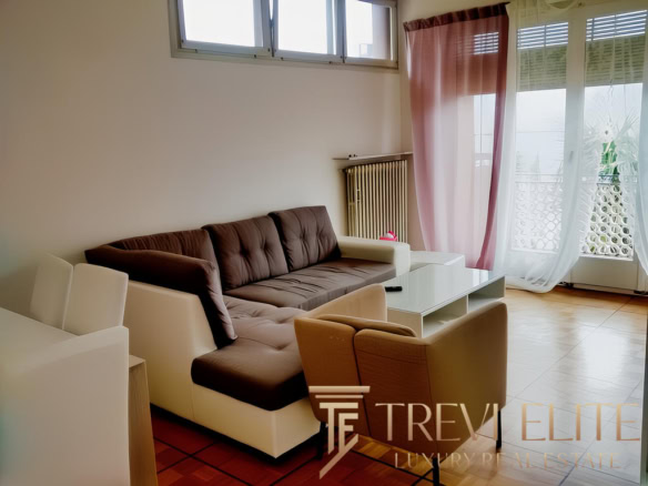 Современная гостиная в avanciertой квартире с большими окнами, мягким диваном и уютной атмосферой, идеально подходит для отдыха и семейных встреч.