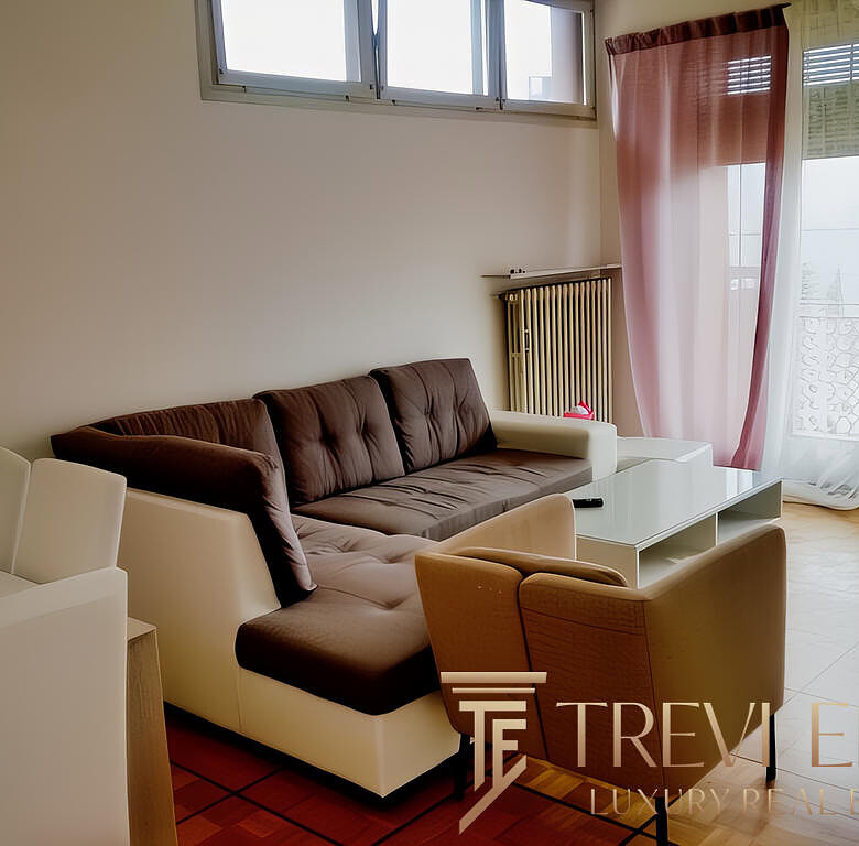 Современная гостиная в avanciertой квартире с большими окнами, мягким диваном и уютной атмосферой, идеально подходит для отдыха и семейных встреч.