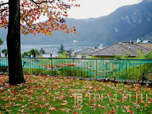 Уютный сад с опадающими осенними листьями, видом на озеро и горы, расположенный в владении недвижимости Треви Элит.