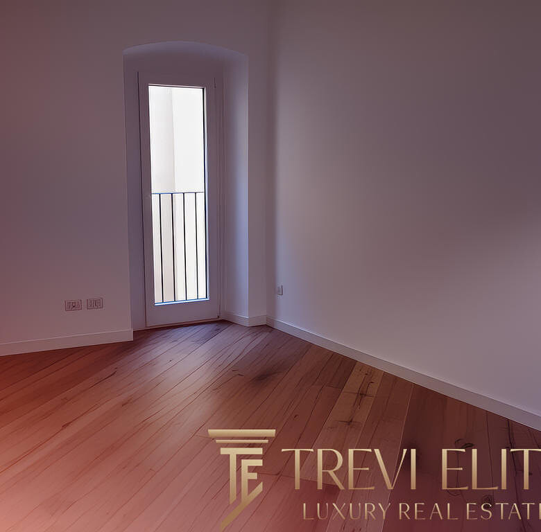 Современный интерьер с белыми стенами и деревянным полом, вход в балкон с металлическим ограждением, светлое пространство, готовое к обустройству.