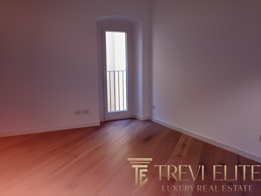 Современный интерьер с белыми стенами и деревянным полом, вход в балкон с металлическим ограждением, светлое пространство, готовое к обустройству.