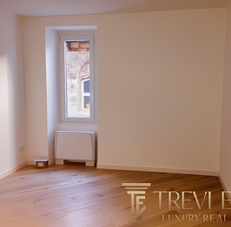 Современная светлая комната с окном и деревянным полом, готовая для меблировки, в новостройке или реконструированном жилом помещении.