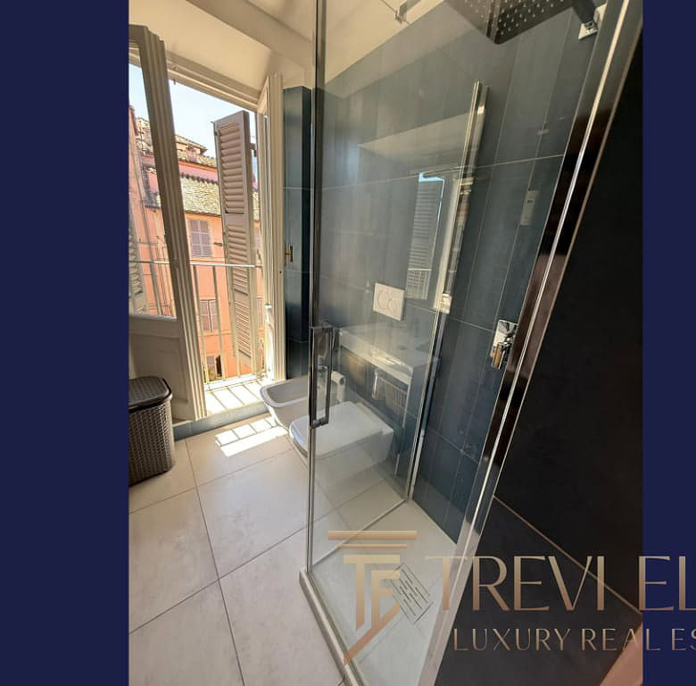 Элитная ванная комната с душевой кабиной и видом на город в центре Милана, светлая и современная, подчеркивающая роскошь и комфорт престижной недвижимости.