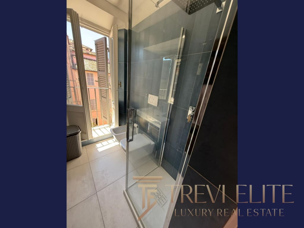 Элитная ванная комната с душевой кабиной и видом на город в центре Милана, светлая и современная, подчеркивающая роскошь и комфорт престижной недвижимости.