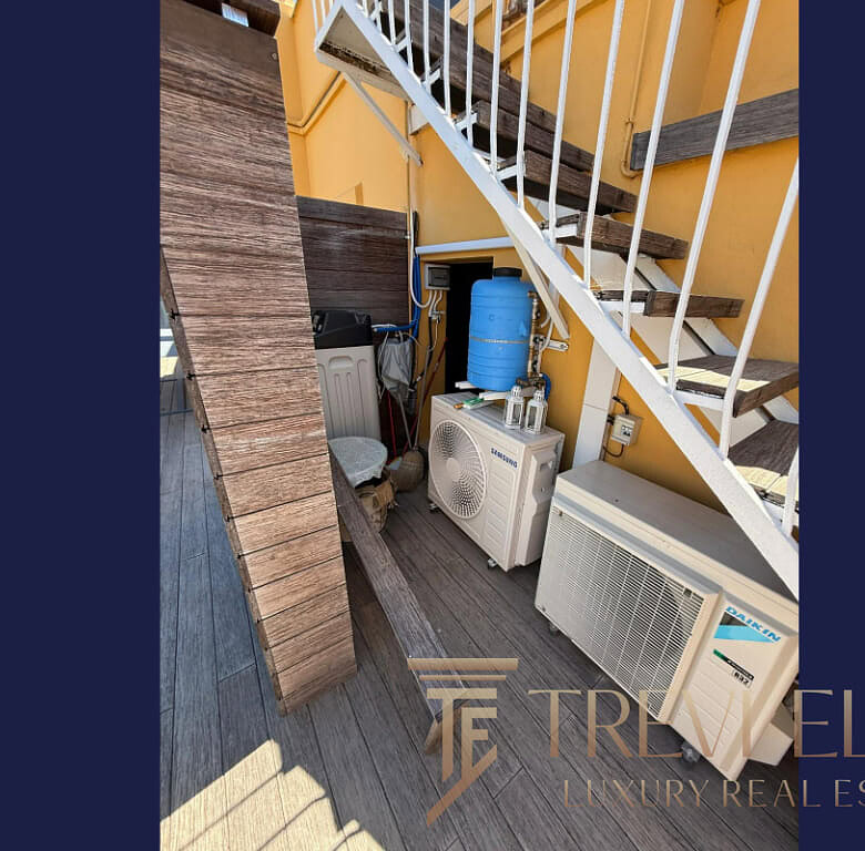 Крупный план кондиционера и системы охлаждения на балконе с лестницей и деревянным настилом, характерный для элитных апартаментов в Италии, предлагаемых агентством Треви Элит.
