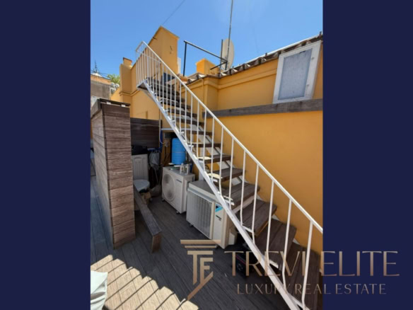 Производственная территория с внешней лестницей и солнечной атмосферой у жёлтой стены. Идеально подходит для элитной недвижимости в Италии и по всему миру, предлагая эксклюзивные объекты с высокой ценностью.