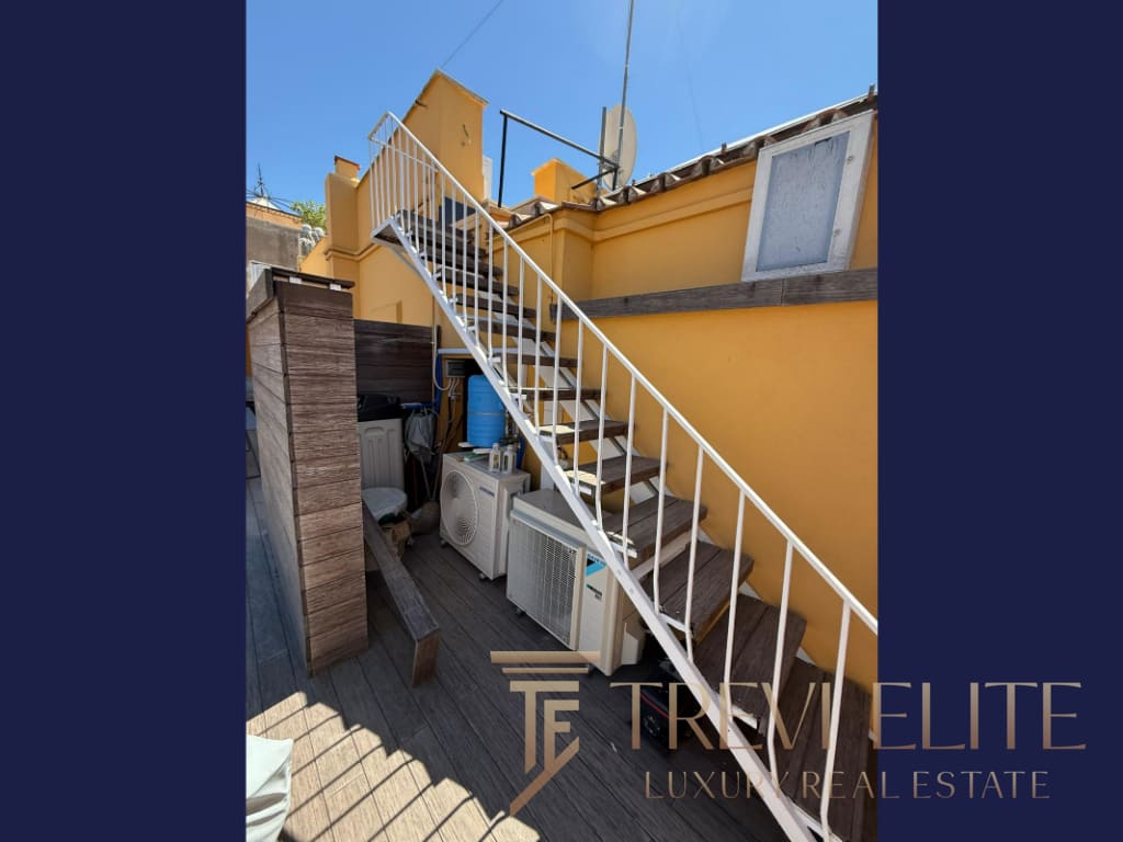 Производственная территория с внешней лестницей и солнечной атмосферой у жёлтой стены. Идеально подходит для элитной недвижимости в Италии и по всему миру, предлагая эксклюзивные объекты с высокой ценностью.