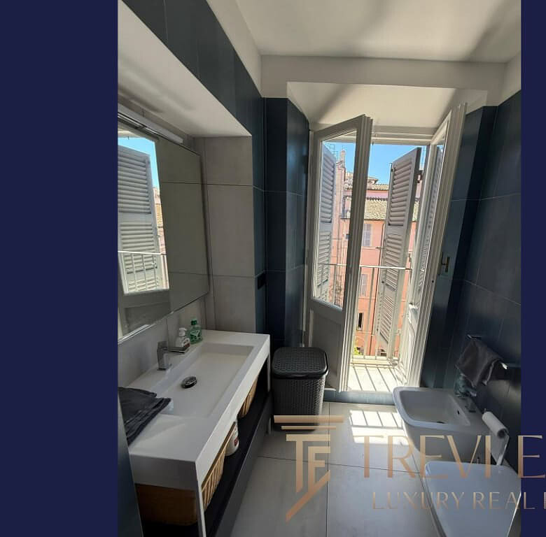 Современная ванная комната с балконом, ярким естественным светом, стильным дизайном, в жилом доме возле центра города.