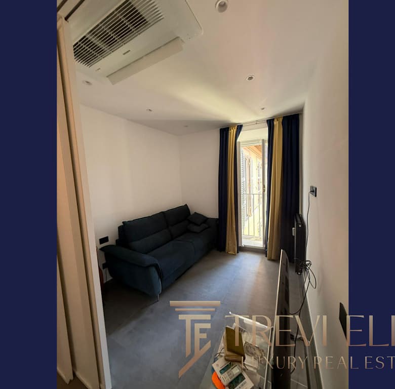 Современный уютный жилой интерьер с просторным балконом, светлым оформлением и удобной мебелью, идеально подходящий для комфортной жизни в элитной недвижимости.