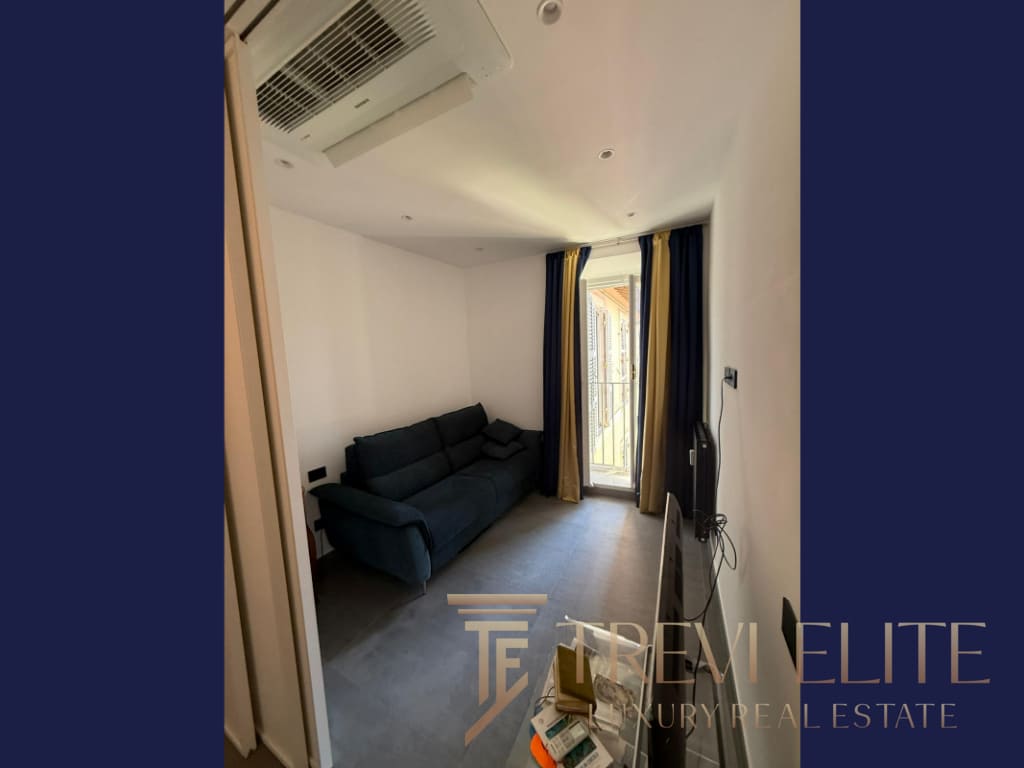 Современный уютный жилой интерьер с просторным балконом, светлым оформлением и удобной мебелью, идеально подходящий для комфортной жизни в элитной недвижимости.