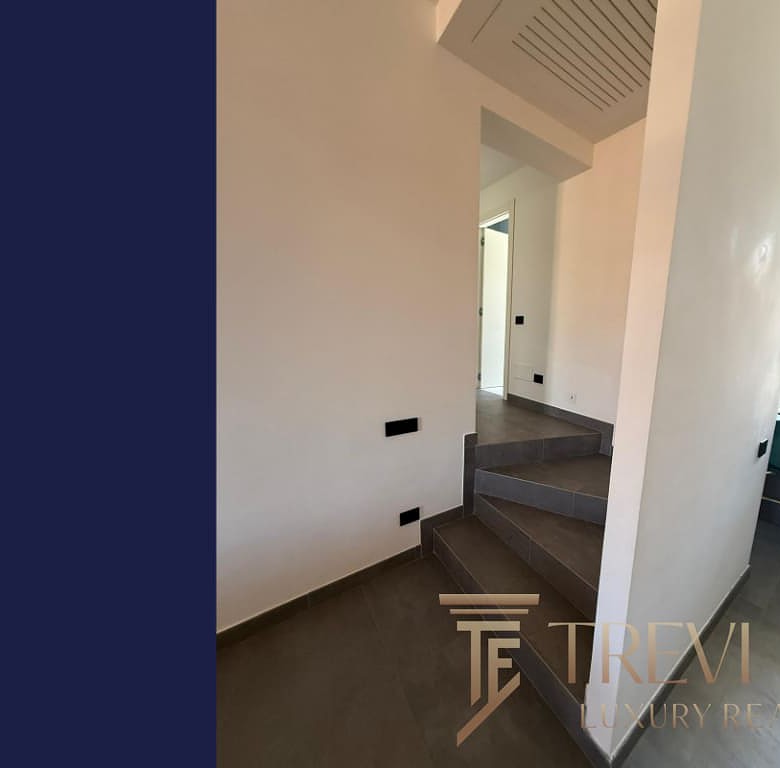 Высококачественный интерьер современного жилья с аккуратными ступенями и светлыми стенами, идеально подходящий для роскошной недвижимости от агентства Треви Элит.