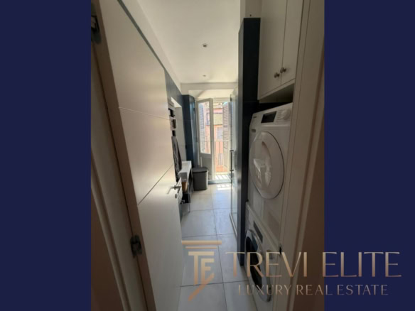 1. Современная компактная кухня с стиральной машиной и выходом на балкон в элитной недвижимости.