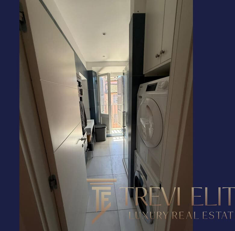 1. Современная компактная кухня с стиральной машиной и выходом на балкон в элитной недвижимости.