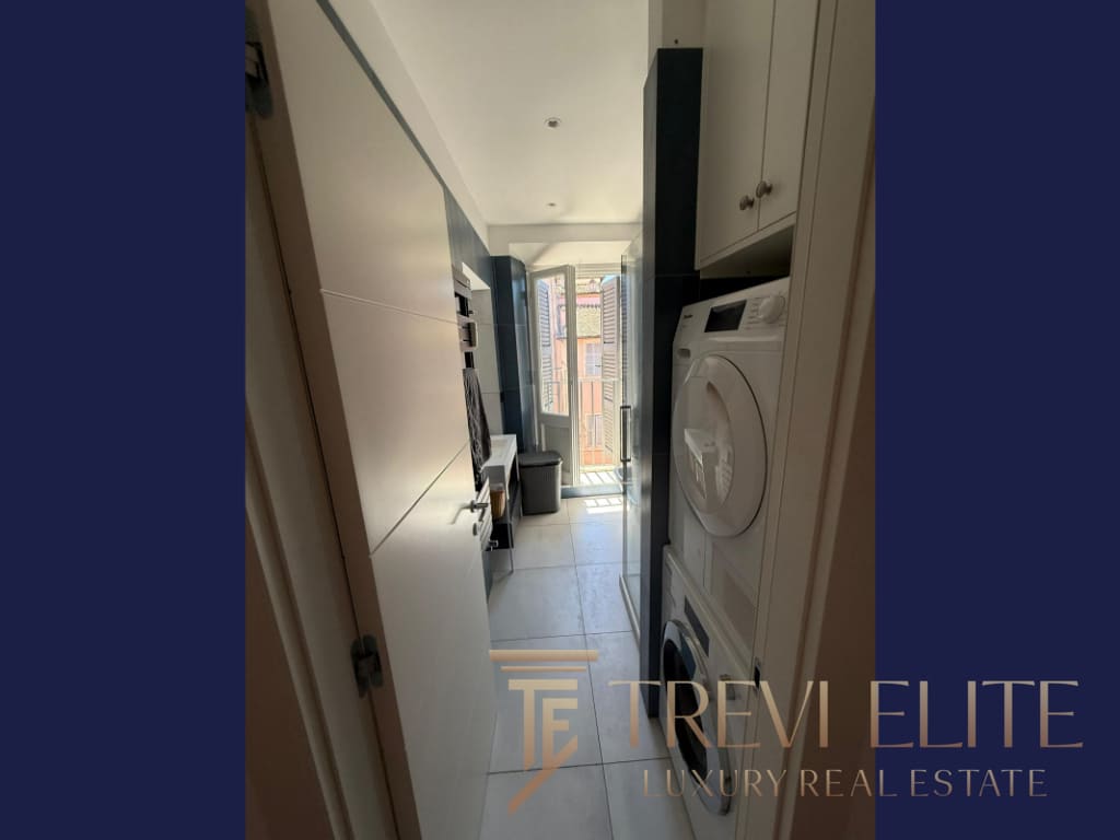 1. Современная компактная кухня с стиральной машиной и выходом на балкон в элитной недвижимости.