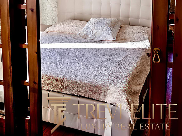 Уютная спальня с мягкой кроватью, украшенной декоративной подушкой, и изысканными шторами на фоне текстурированной стены, подчеркнула гармонию и комфорт интерьера.