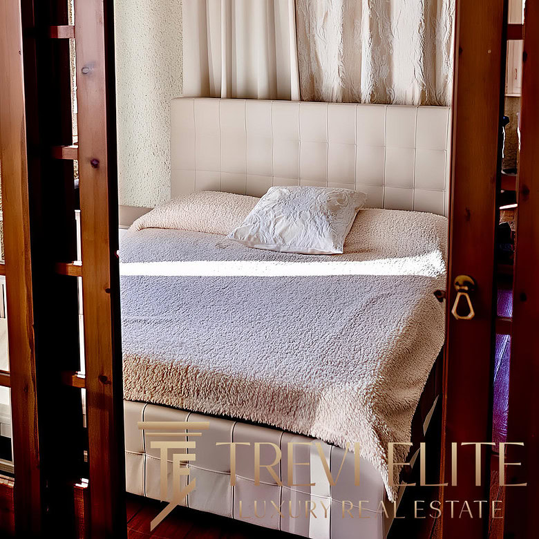 Уютная спальня с мягкой кроватью, украшенной декоративной подушкой, и изысканными шторами на фоне текстурированной стены, подчеркнула гармонию и комфорт интерьера.