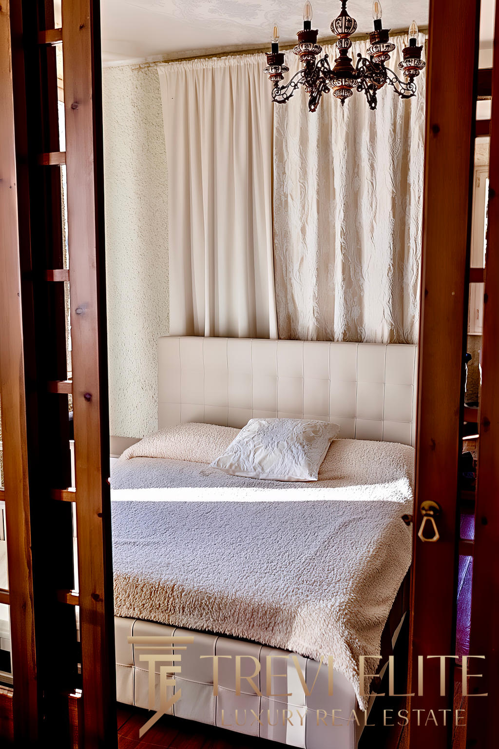 Уютная спальня с мягкой кроватью, украшенной декоративной подушкой, и изысканными шторами на фоне текстурированной стены, подчеркнула гармонию и комфорт интерьера.