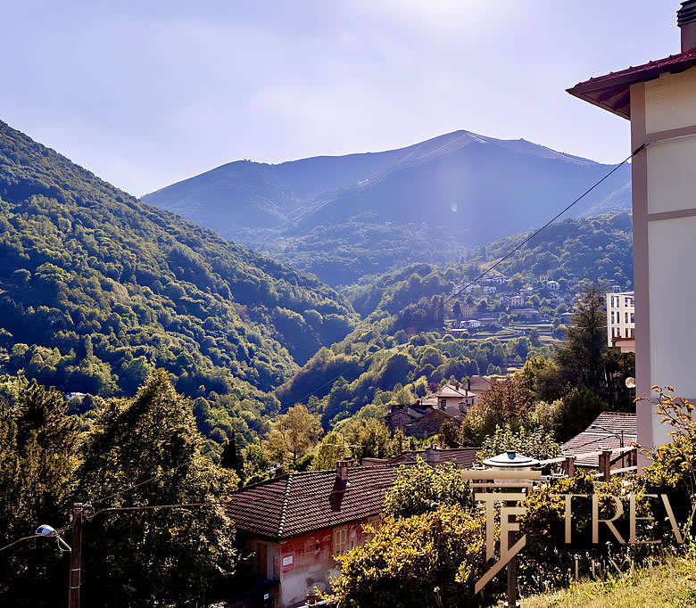 Уютный дом на фоне живописных горных пейзажей, окруженный зеленью и природой, идеально подходит для комфортного проживания и инвестиций в загородную недвижимость.