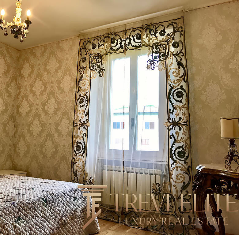 Элегантная спальня с богатым дизайном интерьера, украшенная изыскanym шторами и классической мебелью, светлая и уютная, идеально подходит для комфортного отдыха.